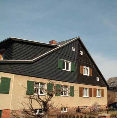 Frontansicht von einem giebelgeteilten Doppelhaus in die Siedlung Am Nuthestrand